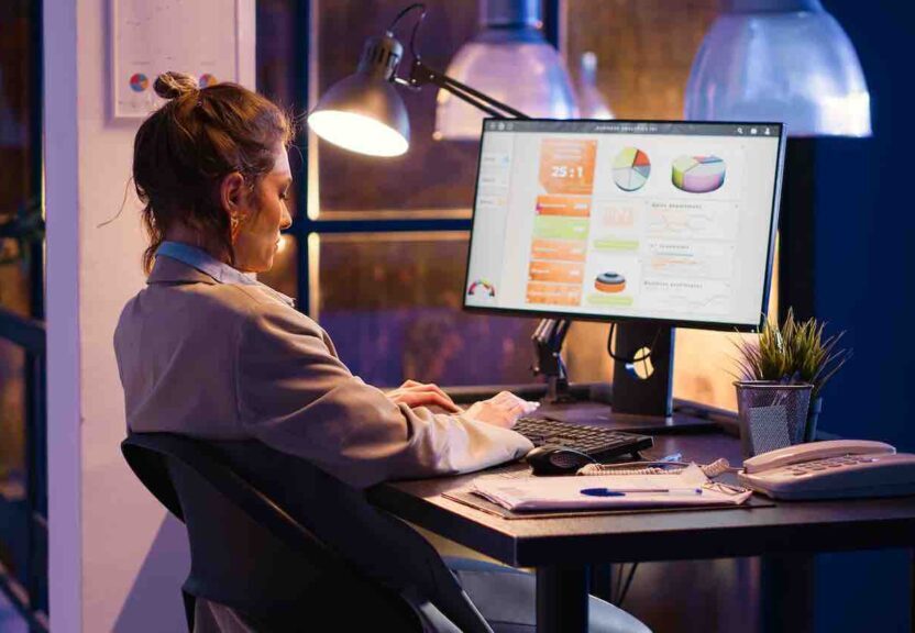 Female manager working on financial statistics in office, analyzing marketing strategy and business growth on online report. Young woman looking at diagrams analytics to plan investment.